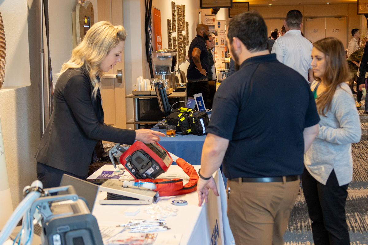 Exhibitor demonstrating product features and benefits to attendee | Texas EMS Medical Director Conference